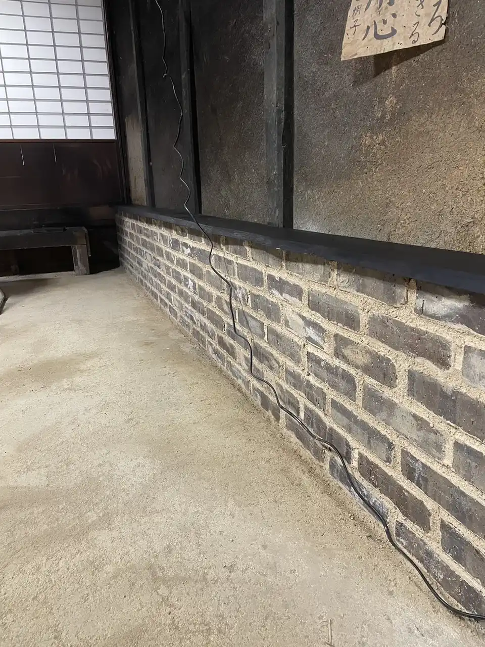 煤で黒くなった土壁と三和土の土間